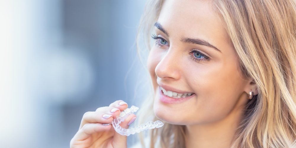 Woman holding Invisalign braces