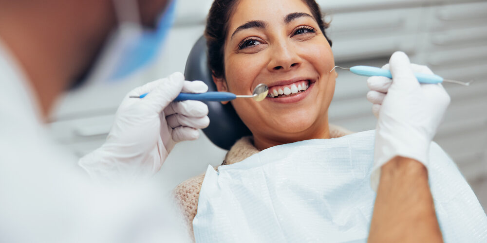Over,The,Shoulder,View,Of,A,Dental,Doctor,Treating,Female women laying in dentist chair
